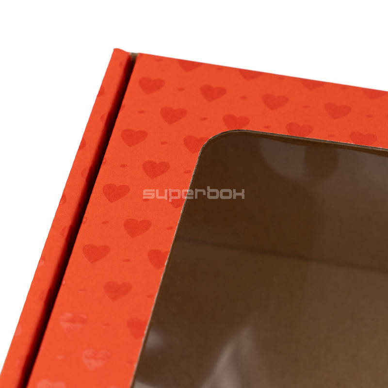 Punainen lahjarasia ikkunalla ja sydänkuviolla Punainen lahjarasia ikkunalla ja sydänkuviolla