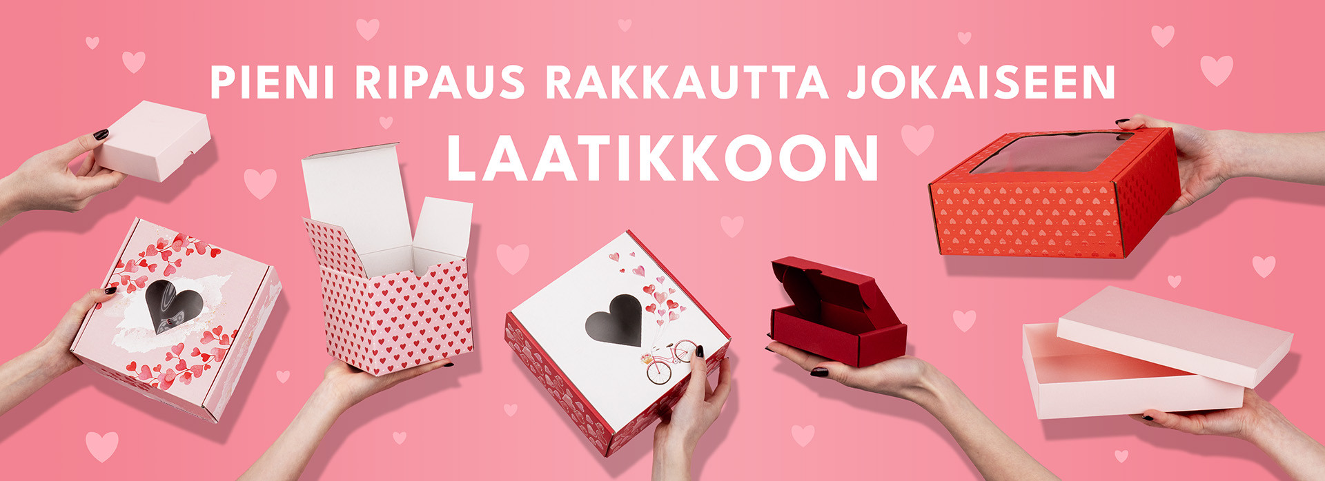 Käsissä pidetyt sydämillä koristellut laatikot roosalla taustalla, teksti “PIENI RIPAUS RAKKAUTTA JOKAISEEN LAATIKKOON”.